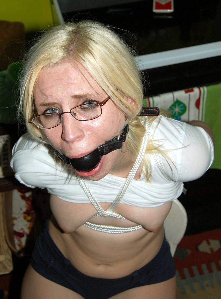 Sklavin mit Brille und Knebel kurz vor ihrer Bestrafung